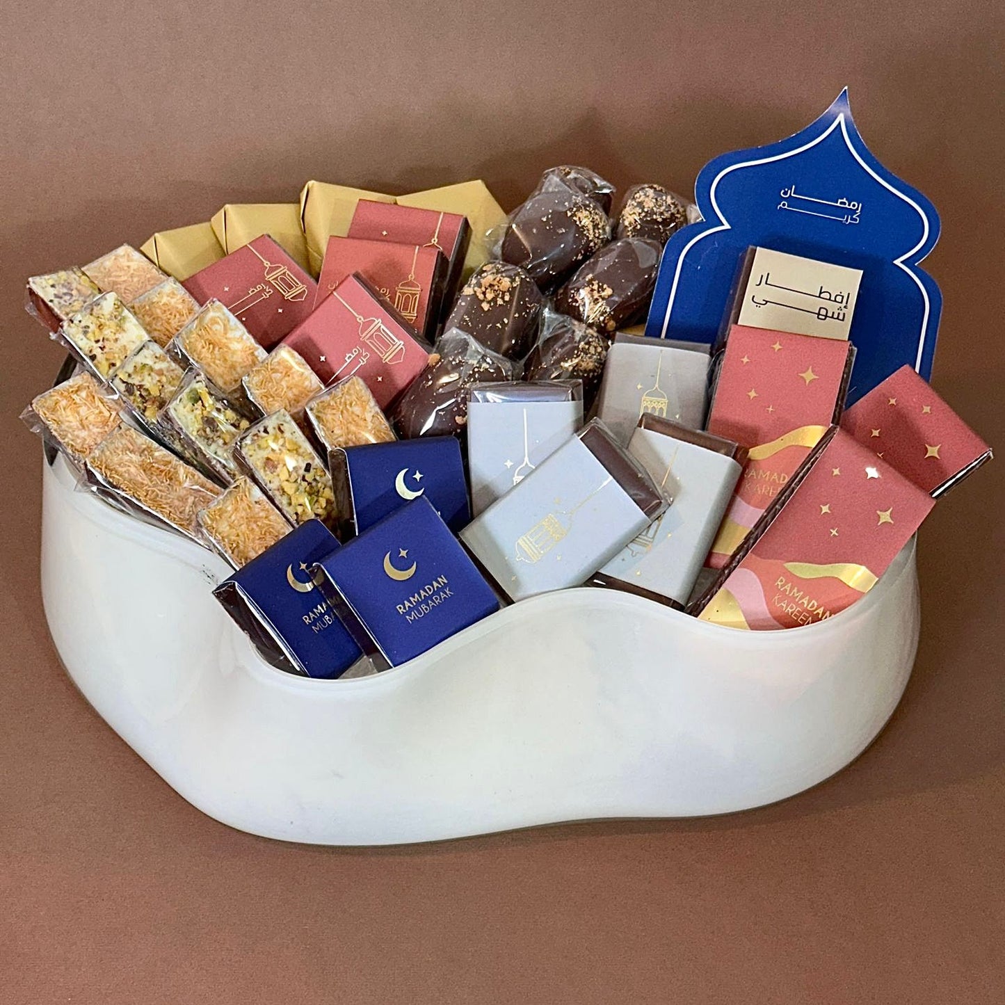 Assorted Ramadan sweets in a curve-shaped vase.