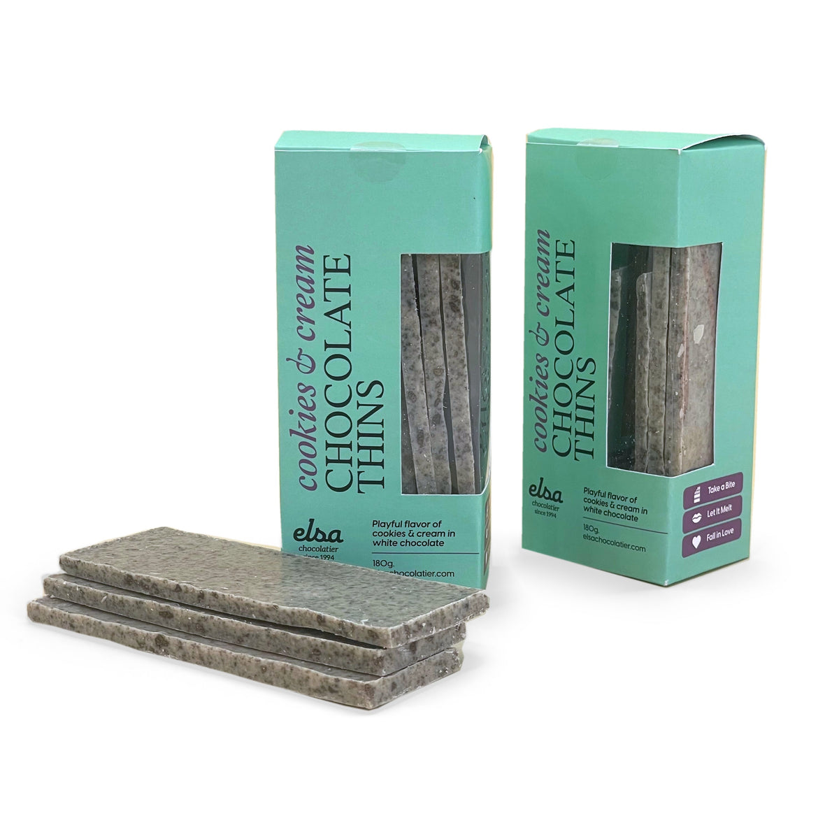 Cookies and cream white chocolate thins stacked beside two turquoise boxes