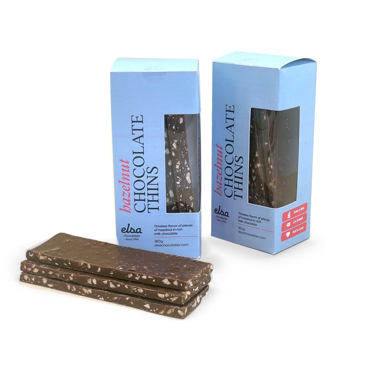 Hazelnut milk chocolate thins stacked beside two blue boxes