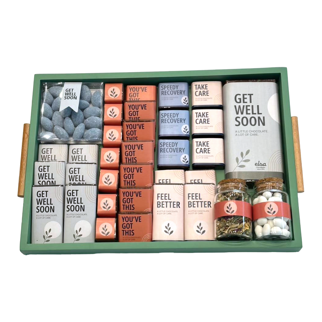 Get Well Soon chocolates and zhourat herbal tea presented in a green wooden tray on a white background