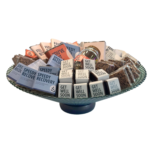Front view of Get Well Soon chocolates arranged on a green glass pedestal plate
